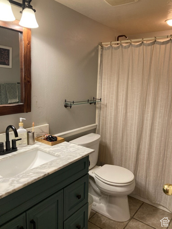 Bathroom with vanity, tile patterned flooring, and a shower with shower curtain