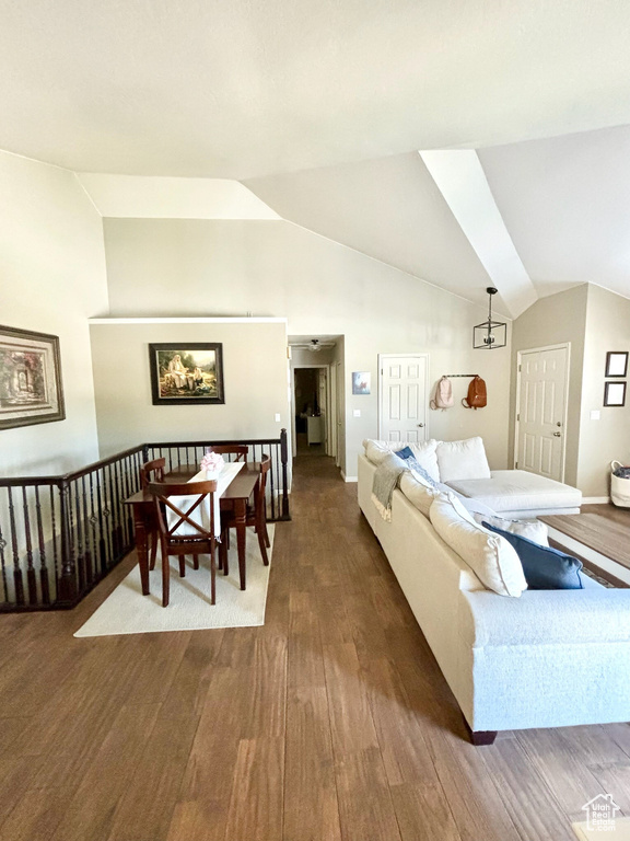 Living area with vaulted ceiling and dark wood-style flooring