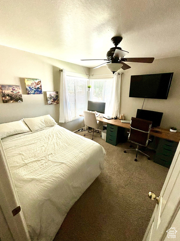 Bedroom featuring a desk, carpet floors, ceiling fan, and a textured ceiling