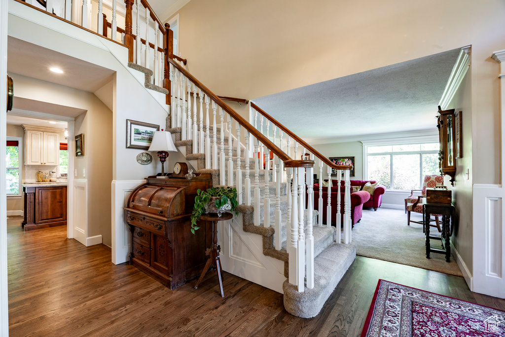 Stairway with wood finished floors and wainscoting