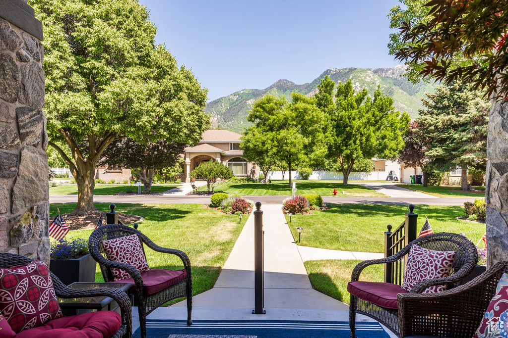 Surrounding community with a mountain view and a yard