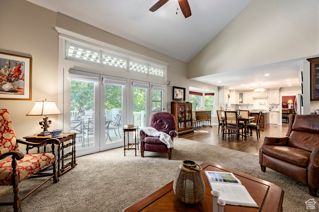 Living area with plenty of natural light, ceiling fan, high vaulted ceiling, and light wood-style flooring