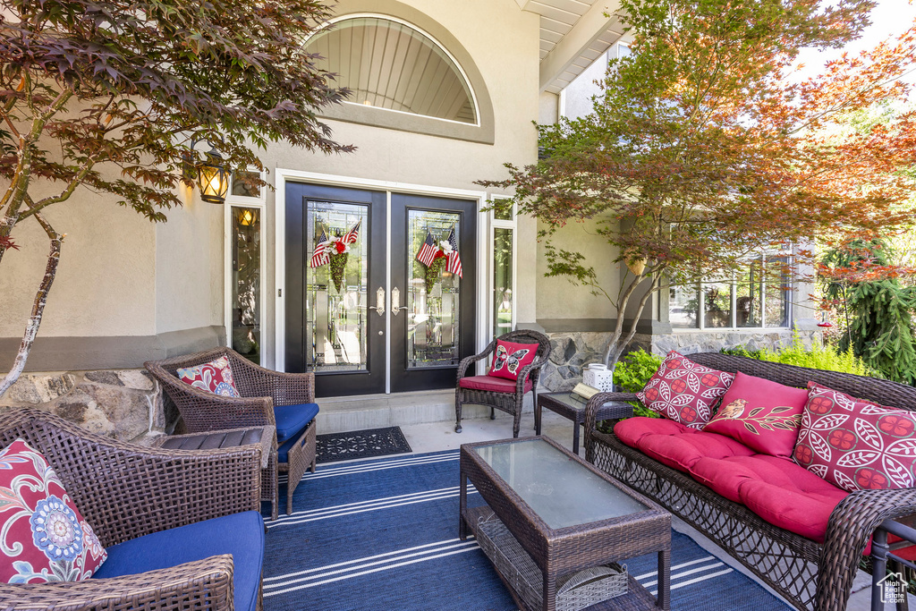 Entrance to property featuring an outdoor hangout area, stucco siding, and french doors