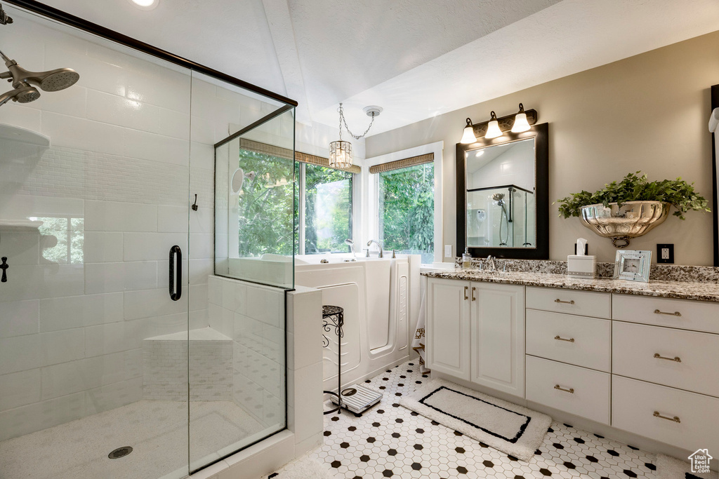 Bathroom with a stall shower, vanity, and a tub to relax in