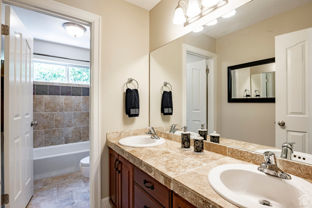 Bathroom with double vanity and shower / bath combination