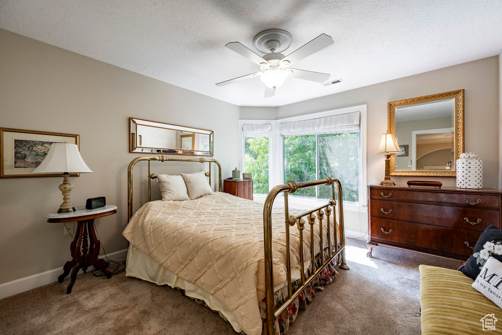Bedroom with carpet, ceiling fan, and a textured ceiling