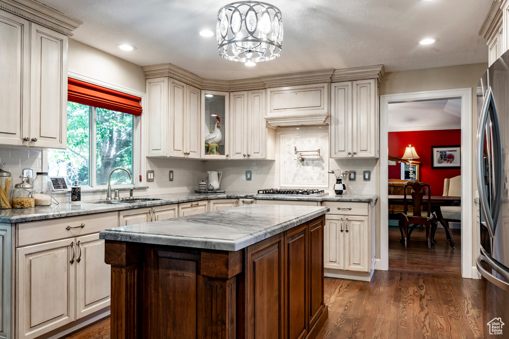 Kitchen with dark wood finished floors, backsplash, stainless steel appliances, glass insert cabinets, and recessed lighting
