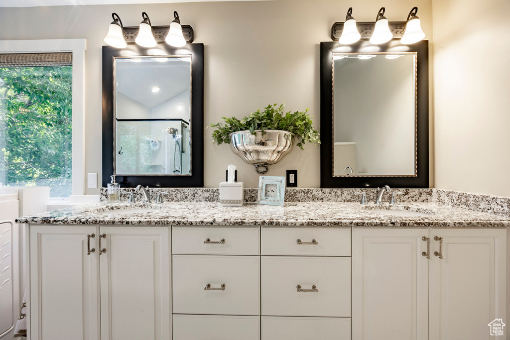 Full bathroom with double vanity and a stall shower