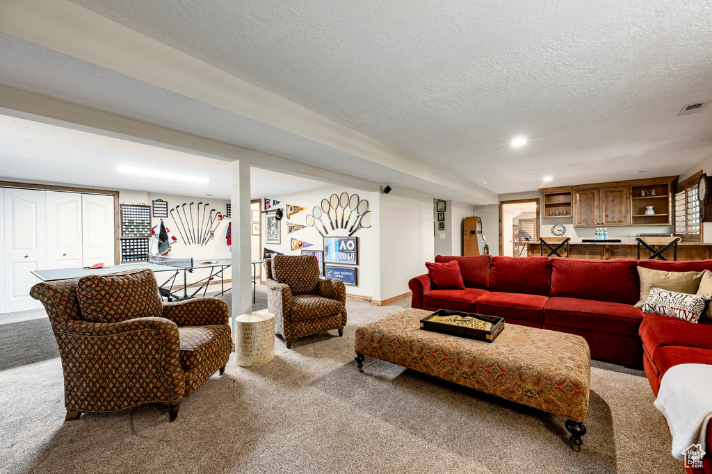 Living room featuring carpet flooring, a textured ceiling, and recessed lighting