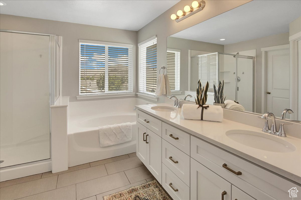Bathroom featuring a stall shower, double vanity, a garden tub, tile patterned floors, and recessed lighting
