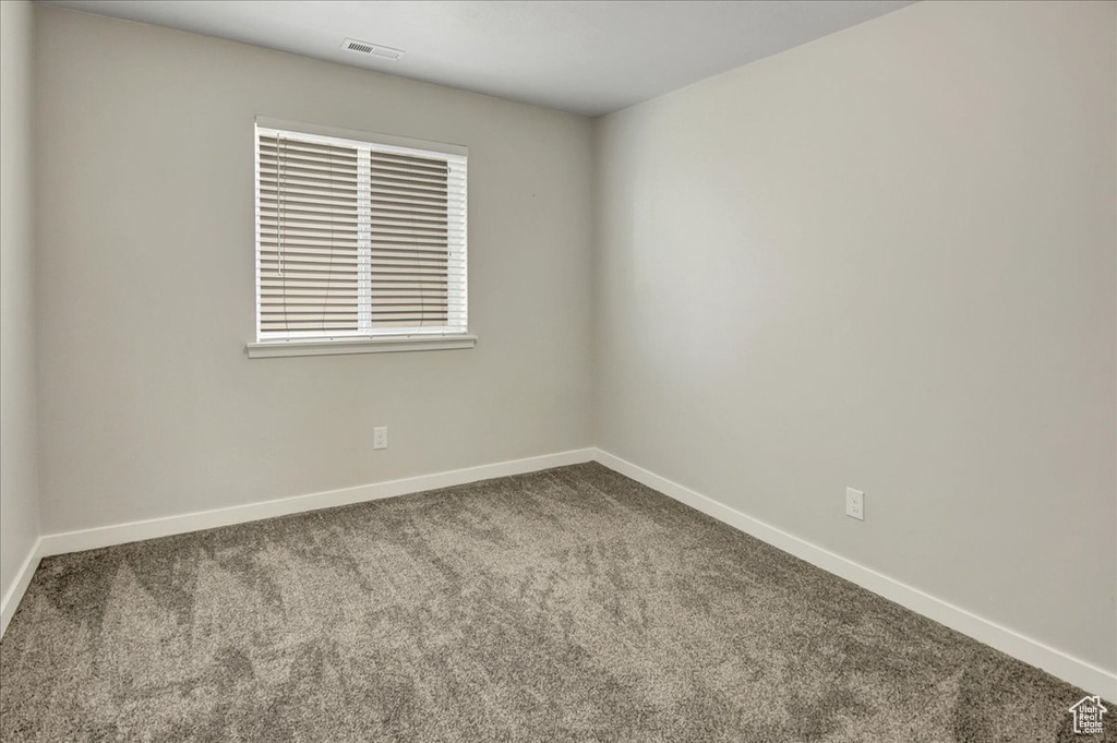 Carpeted empty room featuring baseboards