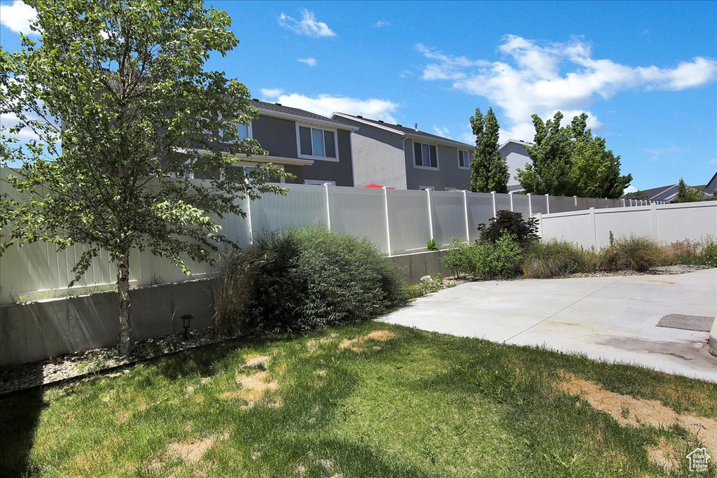 Fenced backyard featuring a patio and a residential view