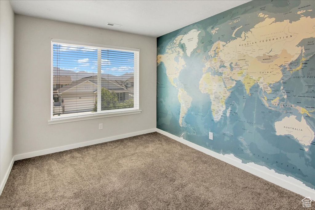 Unfurnished room featuring carpet floors and baseboards
