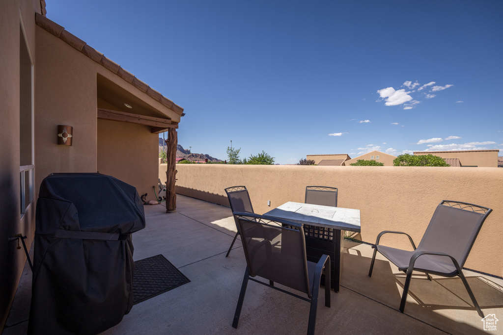 View of patio with outdoor dining area and grilling area