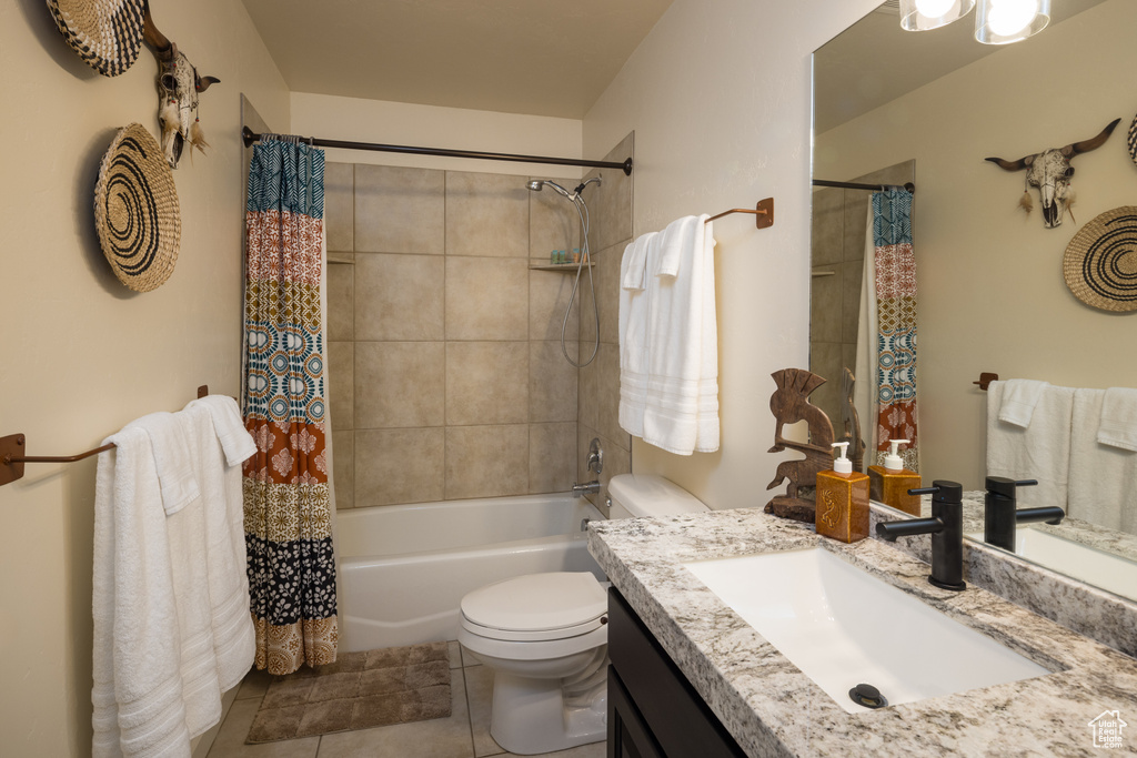 Bathroom featuring vanity, shower / bath combo with shower curtain, and tile patterned floors