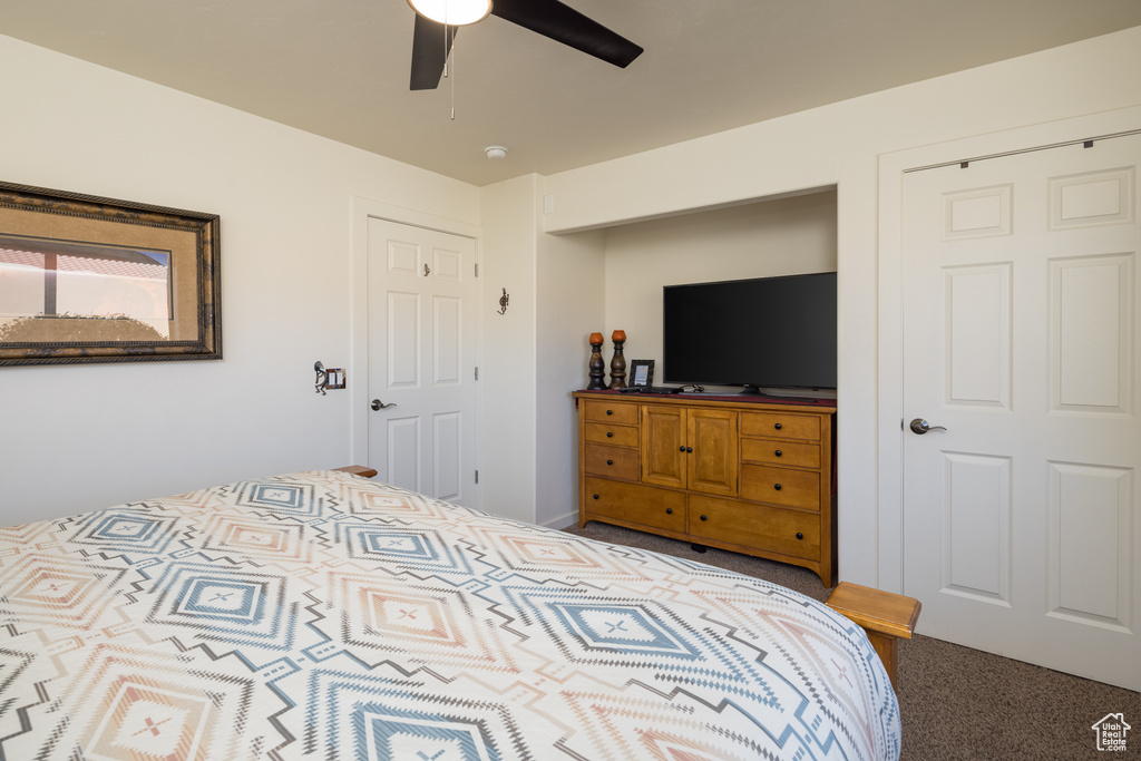 Carpeted bedroom featuring a ceiling fan