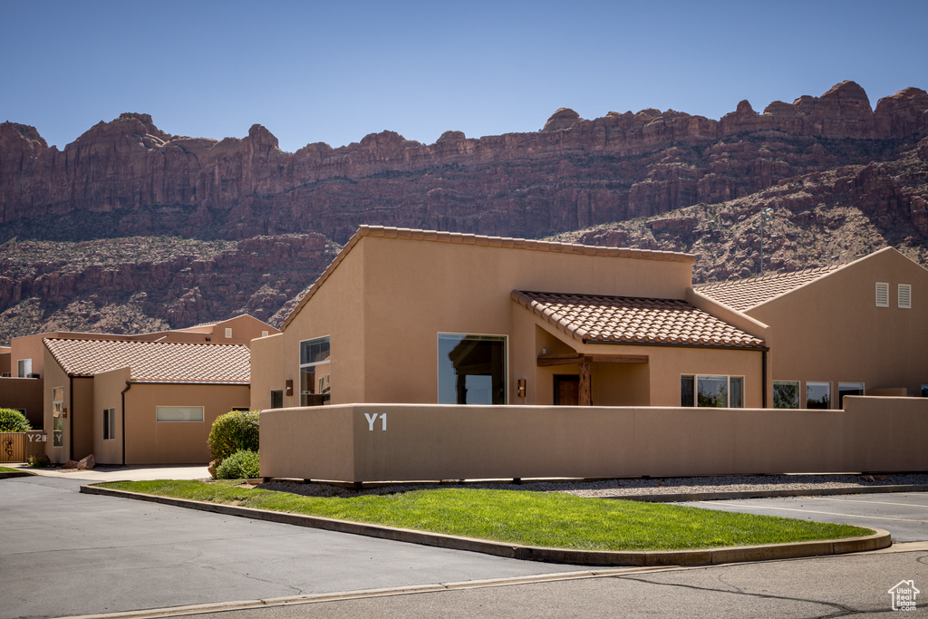 View of front of home with a mountain view, a tile roof, and stucco siding