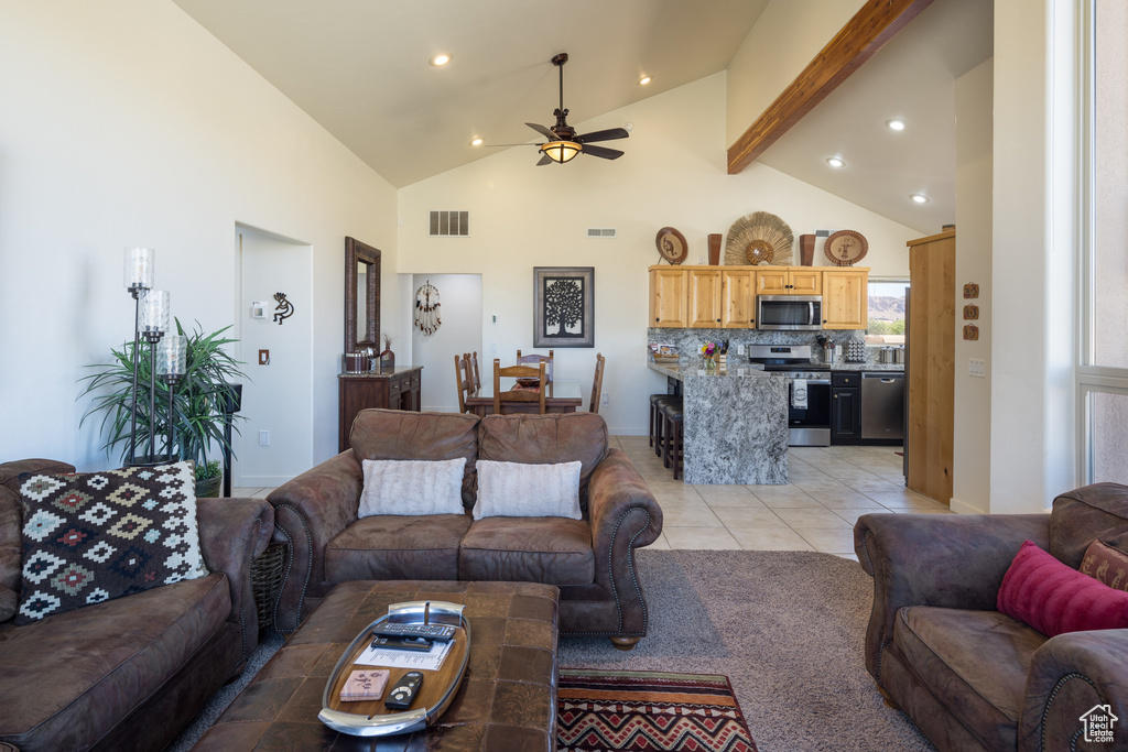 Living room featuring a ceiling fan, recessed lighting, high vaulted ceiling, light tile patterned floors, and beamed ceiling
