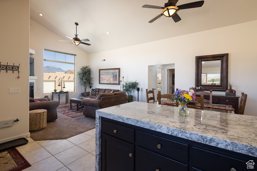 Kitchen with a ceiling fan, light tile patterned floors, high vaulted ceiling, light countertops, and open floor plan
