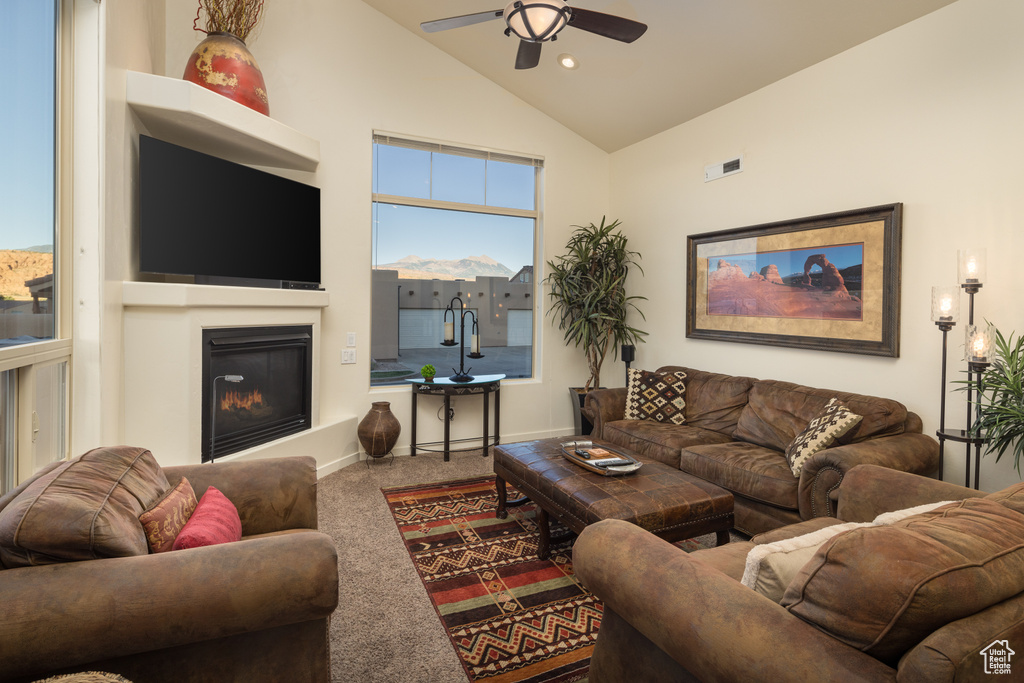 Living area with ceiling fan, carpet floors, a glass covered fireplace, high vaulted ceiling, and recessed lighting