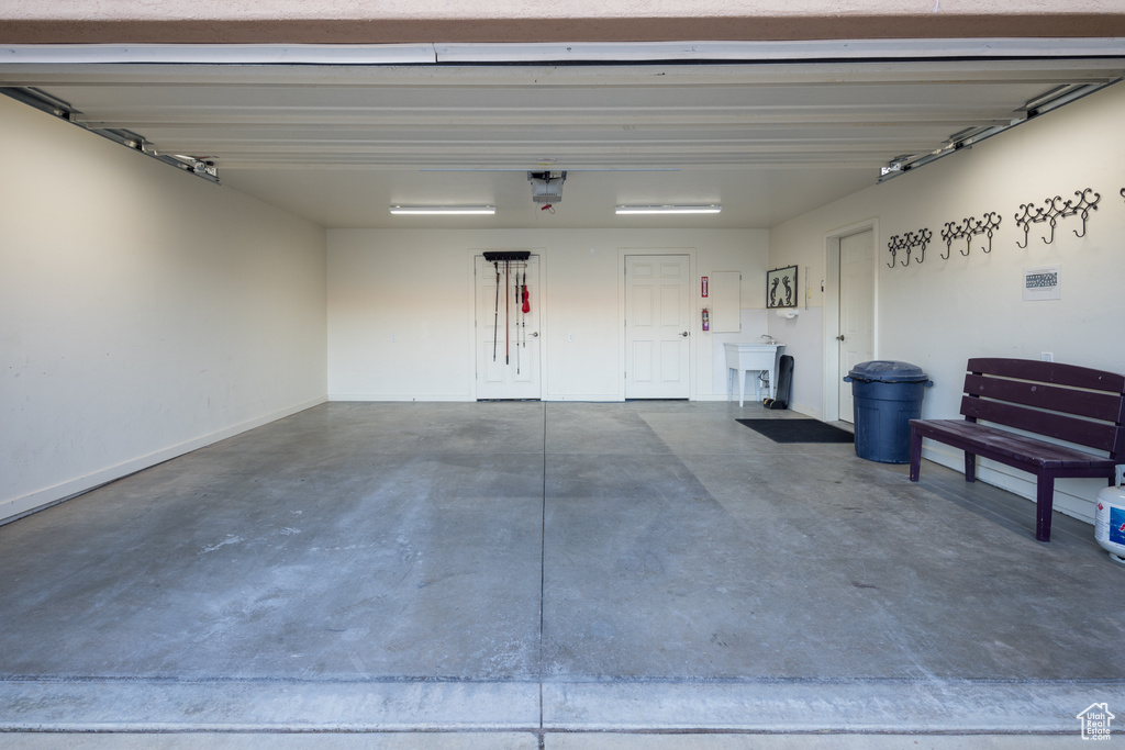 Garage with baseboards and a garage door opener