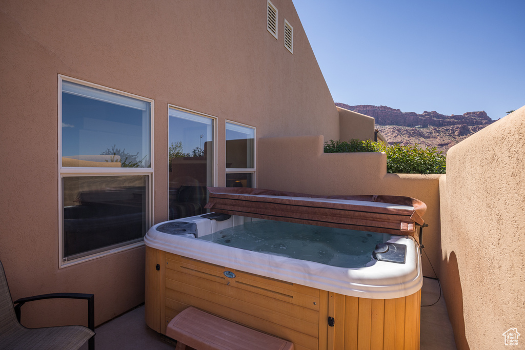 View of patio / terrace featuring a hot tub and a mountain view