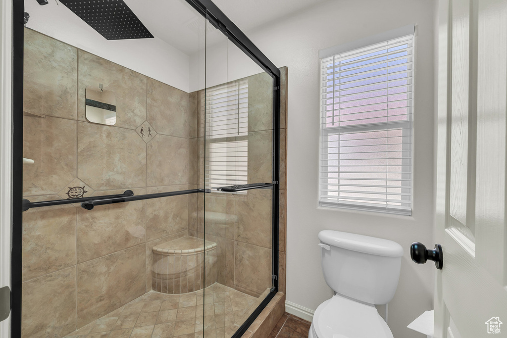 Bathroom with a shower stall and toilet