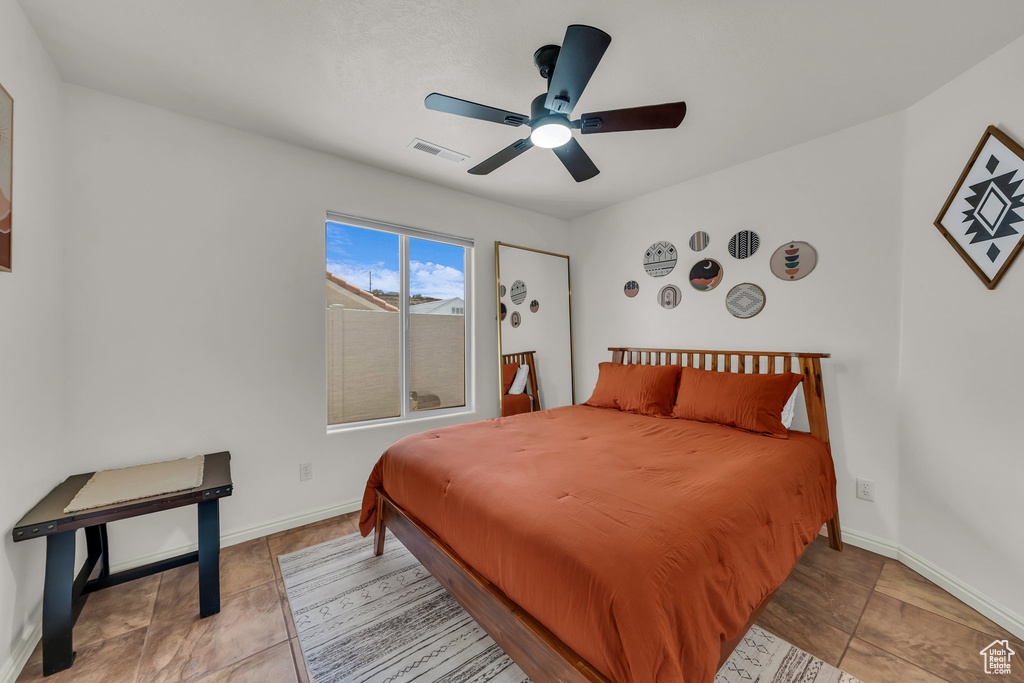 Tiled bedroom featuring baseboards and ceiling fan