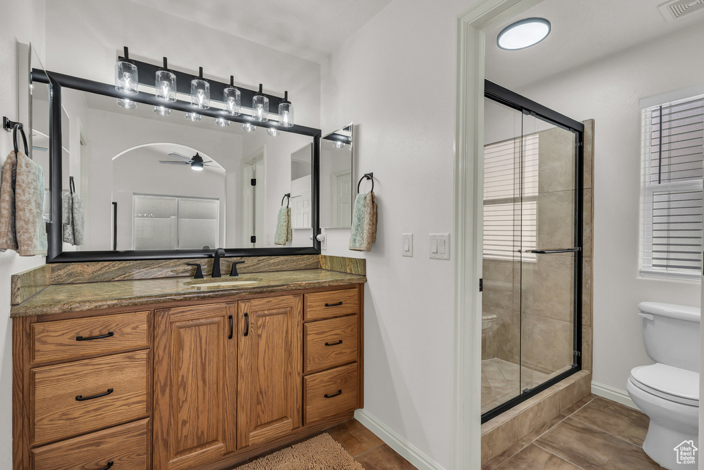 Full bath with a ceiling fan, a stall shower, vanity, and tile patterned floors