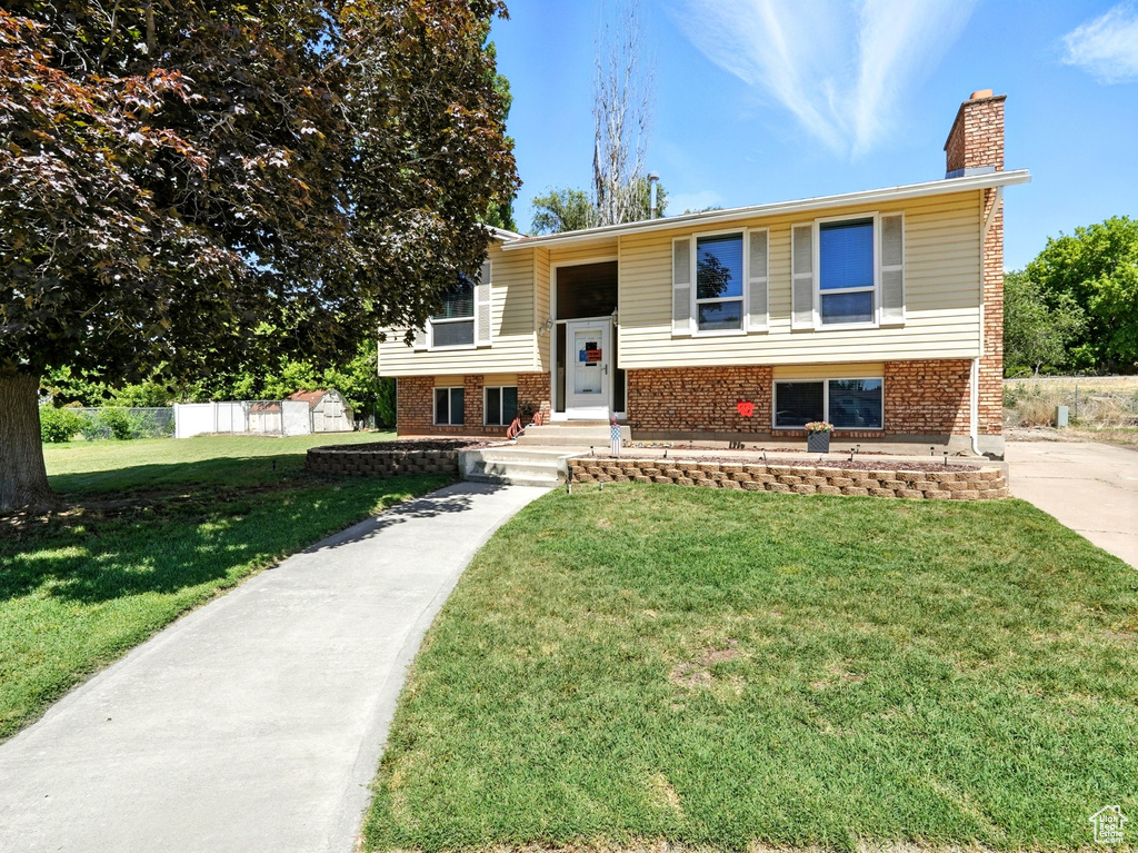 Split foyer home with a chimney and brick siding