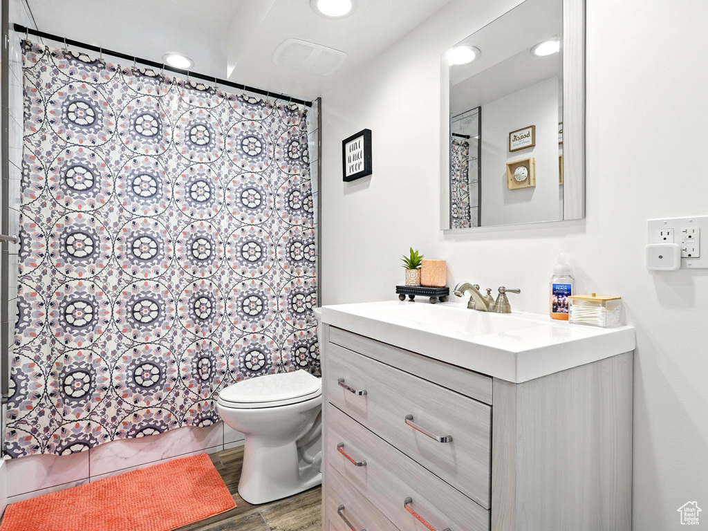 Full bath with vanity, wood finished floors, recessed lighting, and a shower with curtain