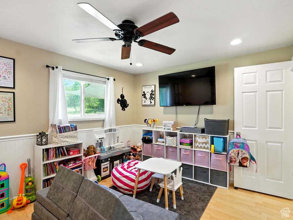 Game room with wainscoting, wood finished floors, a ceiling fan, and recessed lighting
