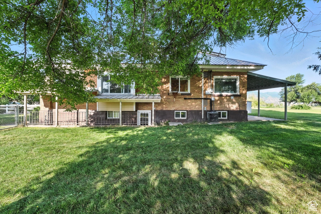 Rear view of house featuring a metal roof, brick siding, and a standing seam roof