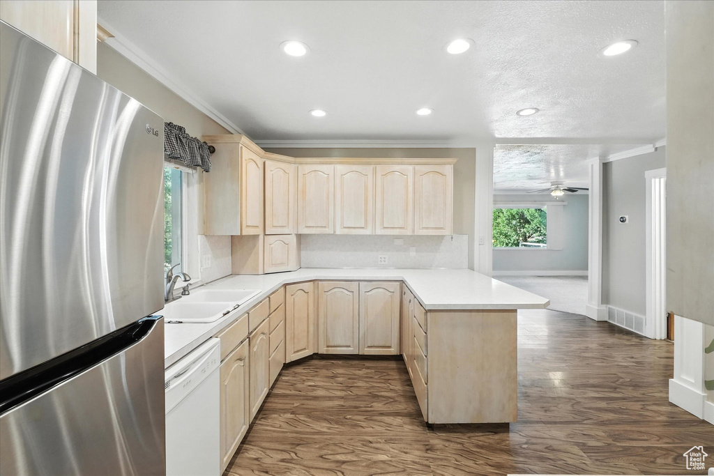 Kitchen featuring freestanding refrigerator, light brown cabinets, white dishwasher, a peninsula, and recessed lighting