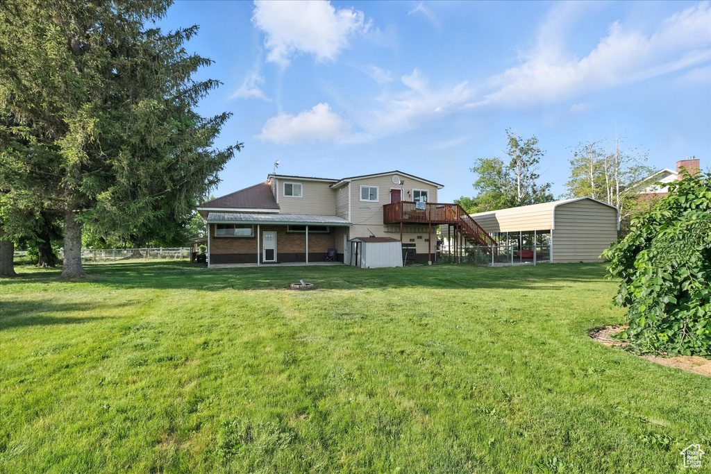 Back of property featuring stairway, a storage shed, and a wooden deck