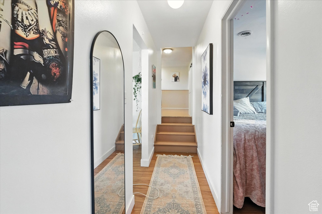 Hall featuring wood finished floors, stairs, and arched walkways