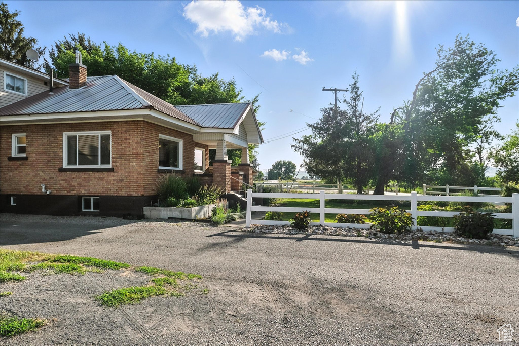 View of home\'s exterior with a chimney, brick siding, and a metal roof