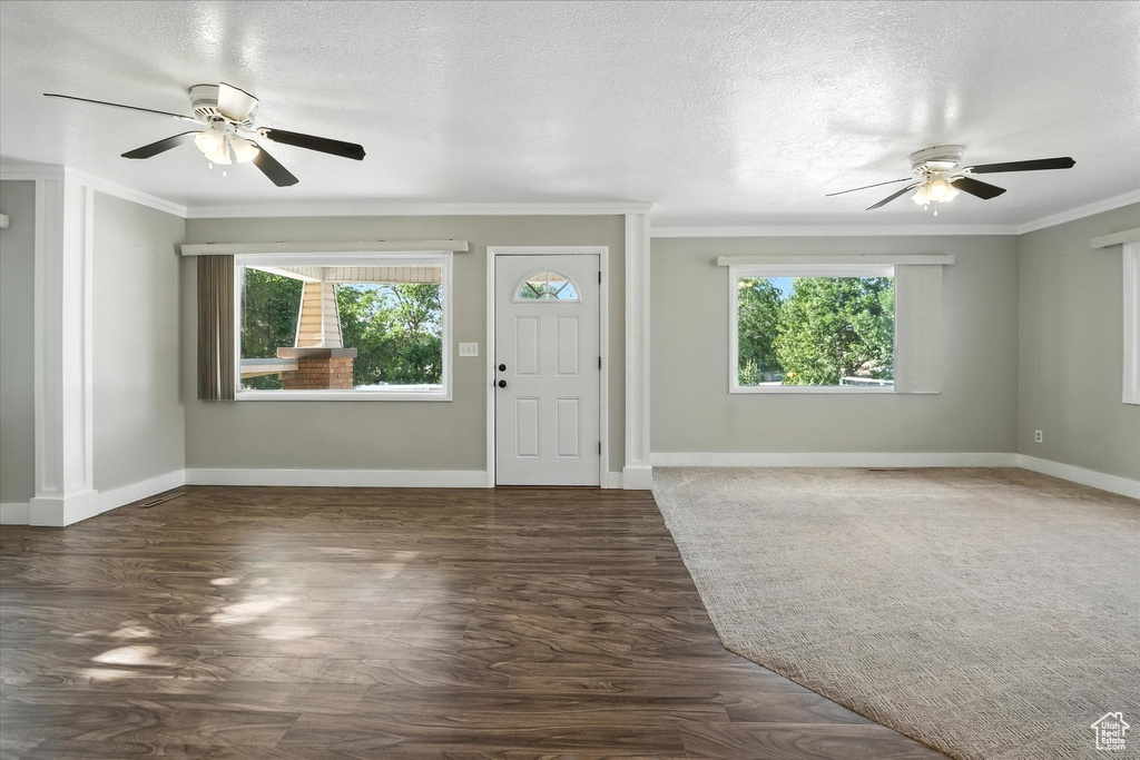 Foyer with a ceiling fan, ornamental molding, wood finished floors, and a textured ceiling