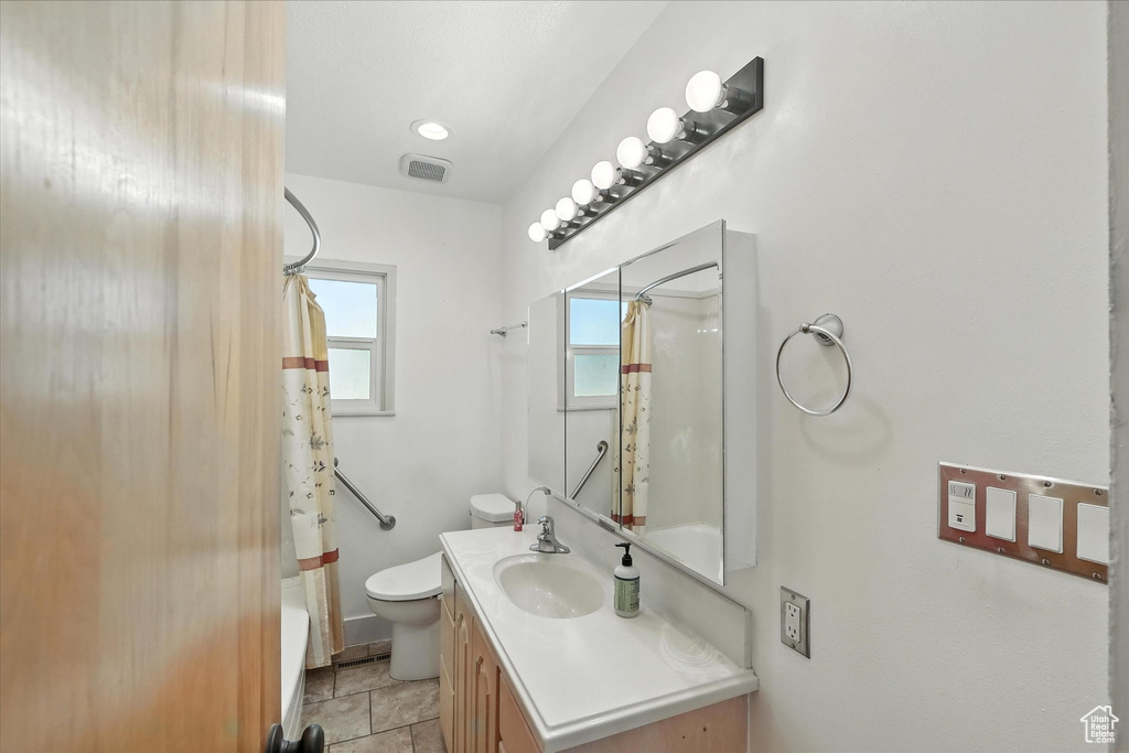 Bathroom featuring vanity and shower / tub combo with curtain
