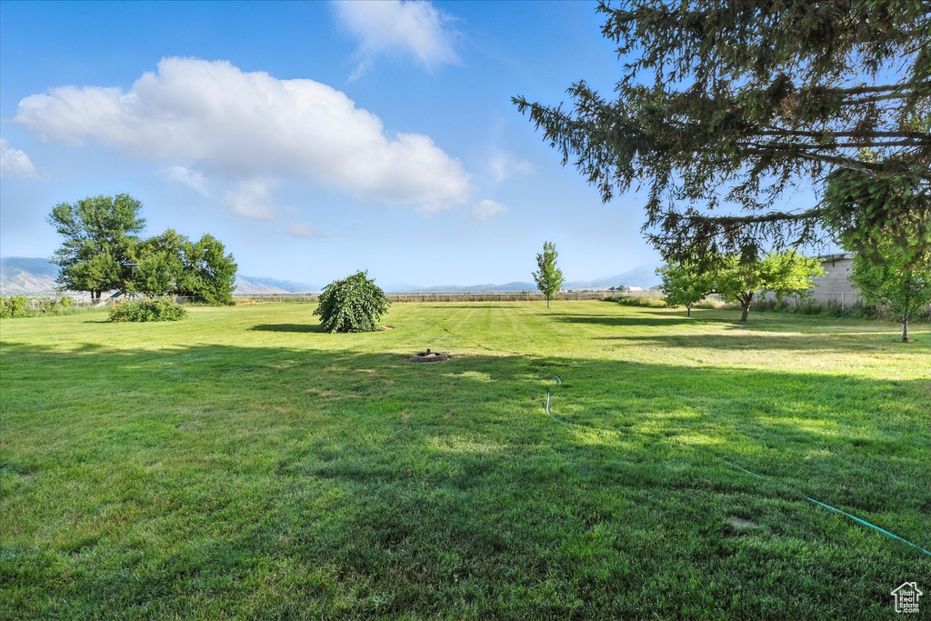 View of grassy yard with a mountain view and a view of countryside