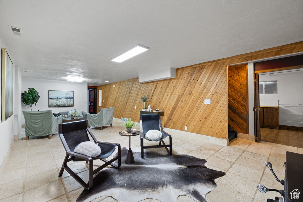 Living area with wooden walls and stone tile flooring