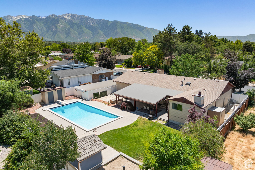 View of pool with a fenced backyard, a mountain view, a patio, a diving board, and a residential view