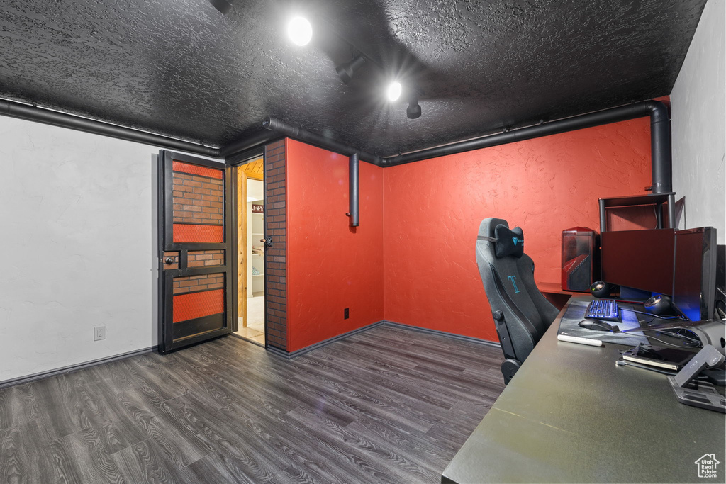 Home office with wood finished floors and a textured ceiling