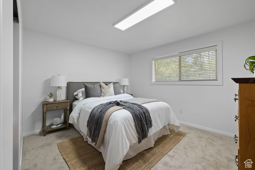 Bedroom featuring carpet and baseboards