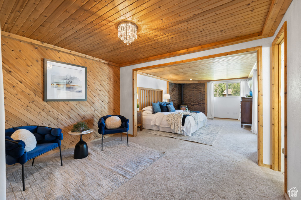 Carpeted bedroom featuring wood ceiling, wooden walls, and a chandelier