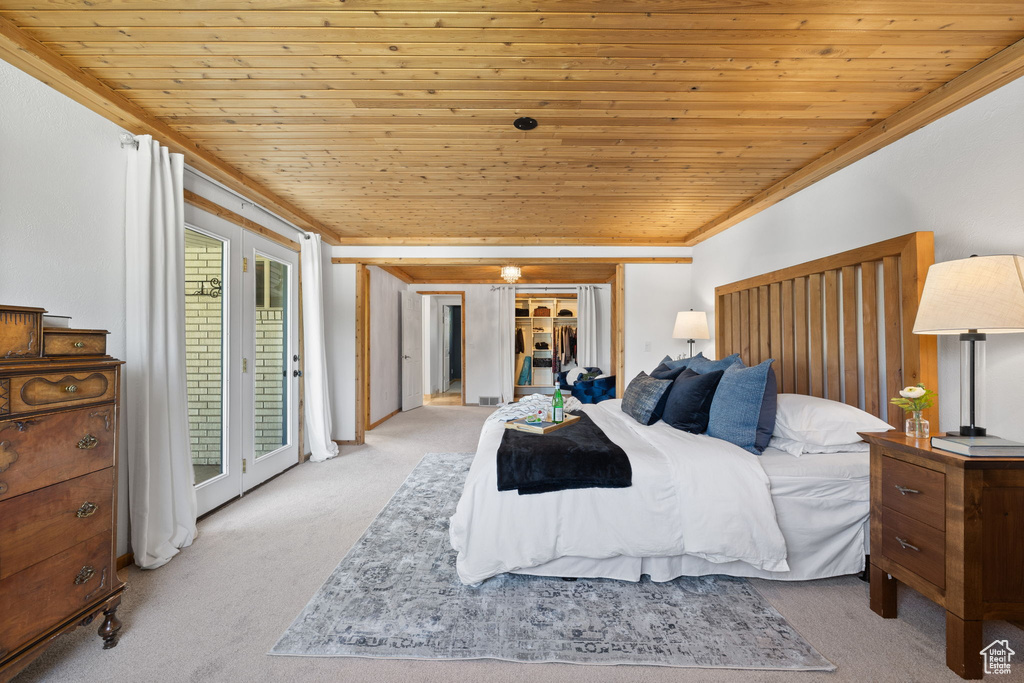 Bedroom featuring carpet, wooden ceiling, crown molding, access to exterior, and a closet