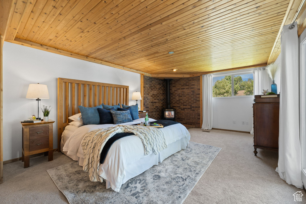 Bedroom featuring wood ceiling, carpet, and a wood stove