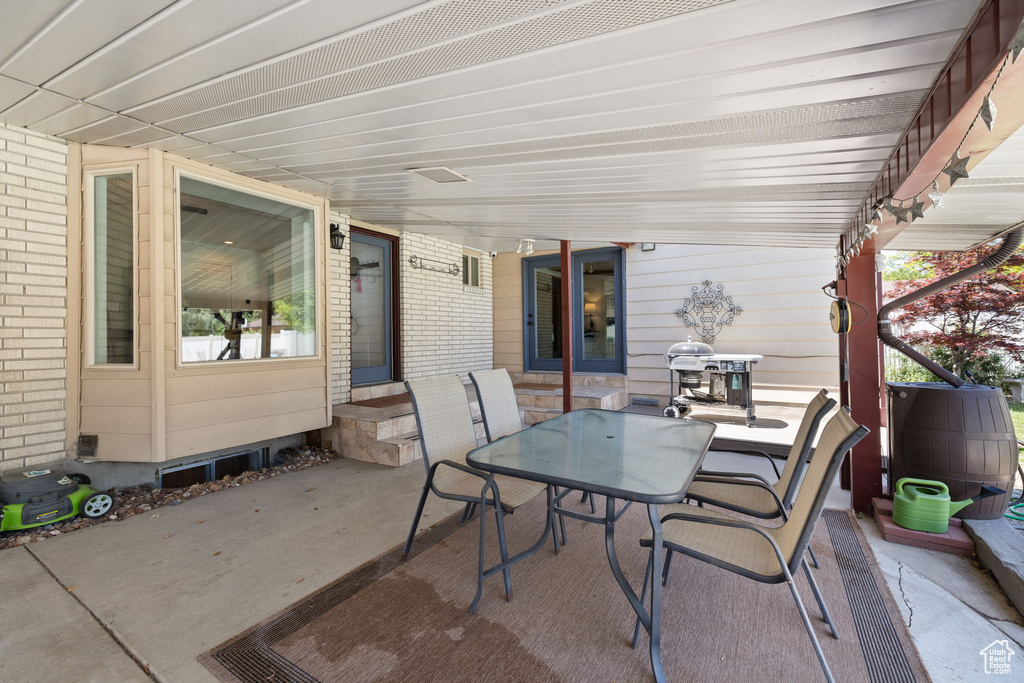 View of patio with entry steps, outdoor dining space, and area for grilling