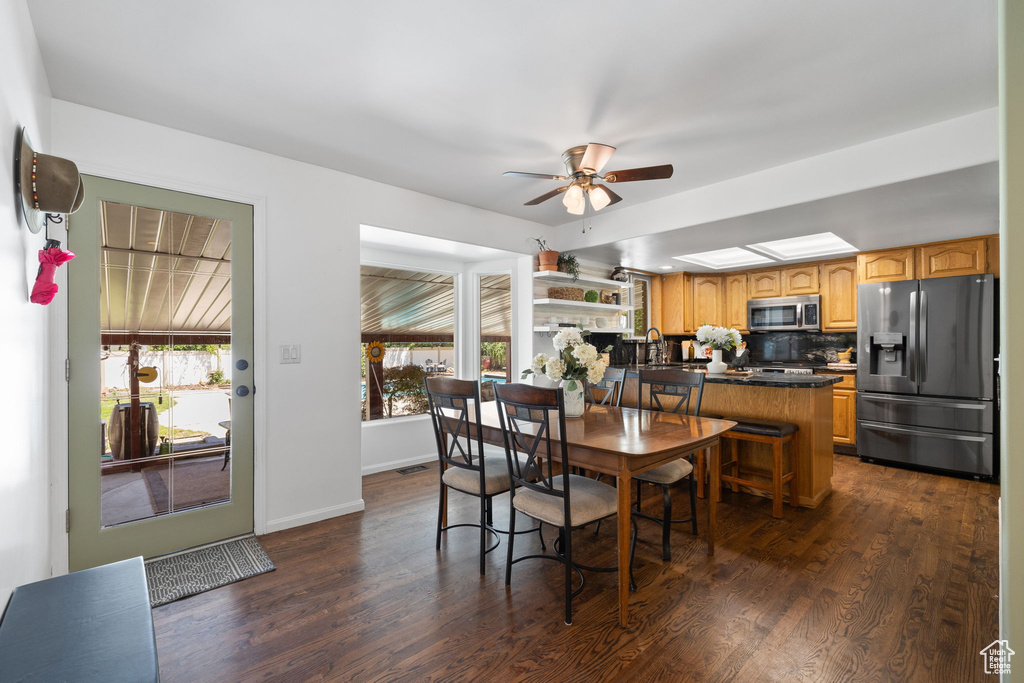 Dining area with a ceiling fan and dark wood finished floors