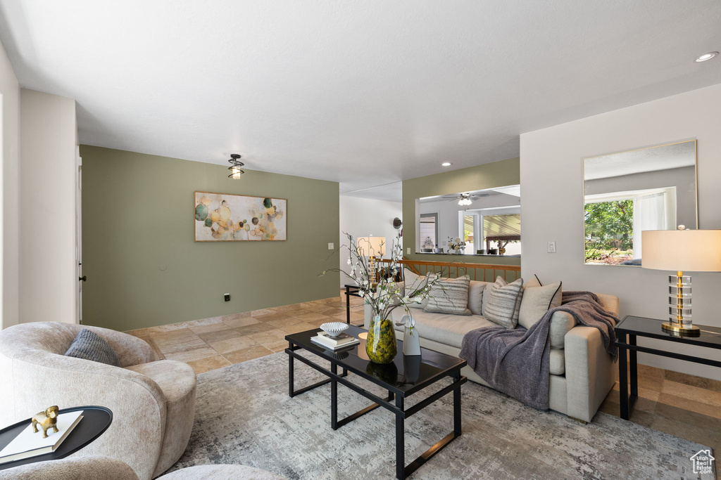 Living room featuring a ceiling fan, recessed lighting, and stone finish flooring